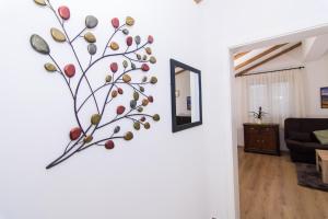 une branche sur le mur d'un salon dans l'établissement Apartman Mišura, à Trogir