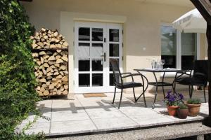 a patio with a table and a pile of fire wood at Studio Dom Nałęczowski in Nałęczów