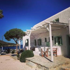 a white pergola on the side of a house at Sunset Studios & Rooms in Antiparos