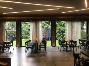 a dining room with tables and chairs and large windows at Restaurace a Penzion U Klásků in Olomouc