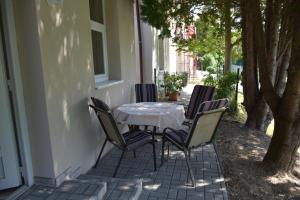 - une table et des chaises assises sur la terrasse couverte d'une maison dans l'établissement Villa Therme Hévíz, à Hévíz