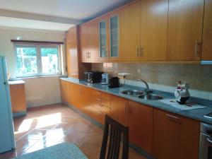 a kitchen with wooden cabinets and a sink at Ares Vieira in Vieira do Minho