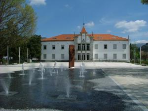 un bâtiment avec une fontaine en face d'un bâtiment dans l'établissement Ares Vieira, à Vieira do Minho