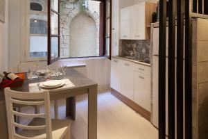 uma pequena cozinha com uma mesa e uma janela em Le Repaire - lescapade-medievale Sarlat em Sarlat-la-Canéda