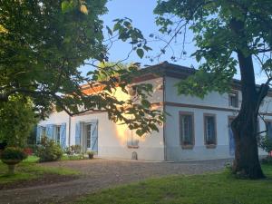 a white house with a tree in front of it at Villa Toulousaine in Grisolles