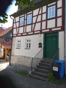 - un bâtiment avec une porte verte et un escalier dans l'établissement Ferienwohnung Leon, à Heldburg