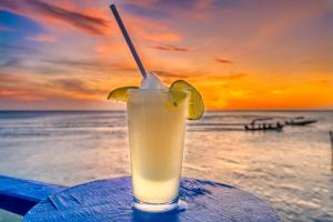 uma bebida sentada em cima de uma mesa na praia em Caribe Tesoro em West Bay