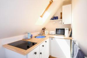 a small kitchen with a sink and a microwave at The Bay Tree Studio in Thorpeness
