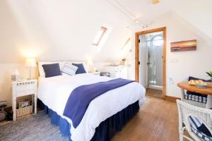 a bedroom with a large bed and a table at The Bay Tree Studio in Thorpeness