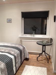 a bedroom with a bed and a table in front of a window at Marna Guesthouse doubleroom nr.4 in Tórshavn