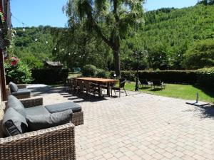 een patio met een tafel en stoelen op een bakstenen patio bij cosy holiday home with sauna near river in La-Roche-en-Ardenne