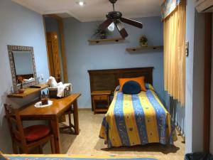 1 dormitorio con cama, escritorio y espejo en Chiki en Peñíscola