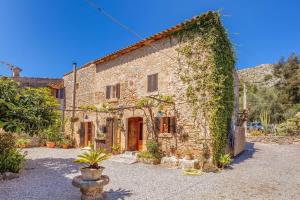 Una casa de piedra con hiedra a un lado. en La font, en Pollensa