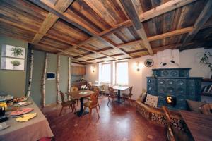 a living room with a stove and tables and chairs at Appartamenti e Camere Veronica in Cogolo