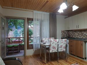 a kitchen with a table and chairs and a balcony at Haros Apart Hotel in Uzungöl
