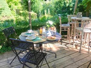 - une table avec des assiettes de nourriture sur une terrasse dans l'établissement La maison O kiwis - Chambres d'hôtes, à Saint-Denis-lès-Martel