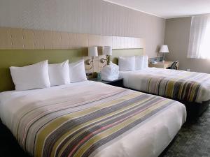 um quarto de hotel com duas camas com almofadas brancas em Country Inn & Suites by Radisson, Delta Park North Portland em Portland