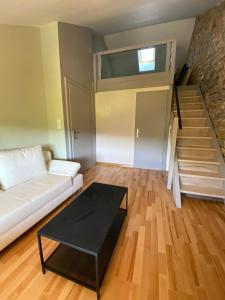 a living room with a couch and a table at La Chambre des Bobines in Montigny-sur-lʼAin