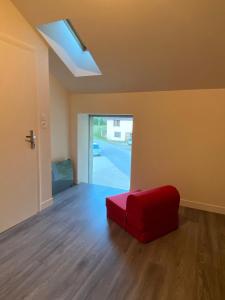 Habitación con reposapiés rojo en el suelo en La Chambre du Tonneau, en Montigny-sur-lʼAin