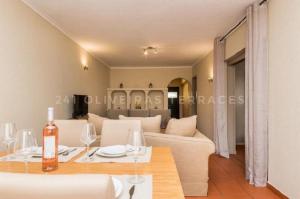 un soggiorno con tavolo e divano di 241 Oliveiras Terraces ad Albufeira