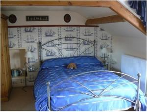 a dog laying on a blue bed in a bedroom at Captains Cabin in Whitby