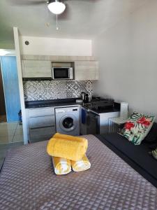 Cette chambre comprend une cuisine et un lit avec une table. dans l'établissement Little home Tahiti, à Papeete