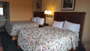 
a hotel room with two beds and a lamp at Garden Inn and Extended Stay in Shepherdsville

