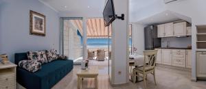a living room with a blue couch and a kitchen at Apartmani D&D Sosič in Brela