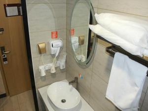 a bathroom with a white sink and a mirror at 7Days Premium Qingdao Ocean World Haiyou Road Subway Station Branch in Qingdao