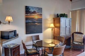 a living room with a table and chairs and a tv at Maui Vista 1422 in Kihei