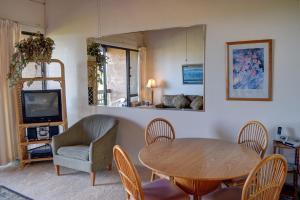 a living room with a table and chairs and a mirror at Maui Vista 1423 in Kihei