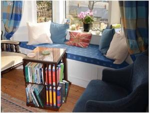 a living room with a blue couch and a window at Captains Cabin in Whitby