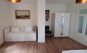 sala de estar con sofá blanco y silla en Pineapple Apartments Dresdner Heide mit Garten, en Dresden
