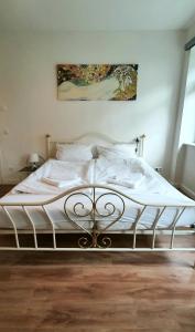 - une chambre dotée d'un lit avec des draps blancs dans l'établissement Pineapple Apartments Dresdner Heide mit Garten, à Dresde