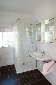 a white bathroom with a sink and a shower at Milica Garden in Prvić Šepurine