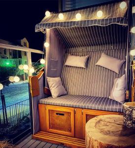 an outdoor bench with pillows on a balcony at Apartament MONSTERA in Dziwnówek