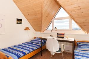 a bedroom with a desk and a bed and a window at Ferienhaus Malgosia direkt am See in Kruklanki