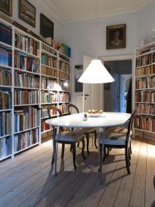 ein Esszimmer mit einem Tisch und Stühlen vor den Bücherregalen in der Unterkunft ApartmentInCopenhagen Apartment 931 in Kopenhagen