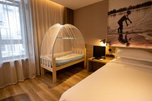 a room with a bed and a crib with a window at Urban Rosa Cafe&Inn in Shanghai