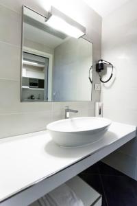 a bathroom with a white sink and a mirror at 57 Reshotel Orio in Orio al Serio