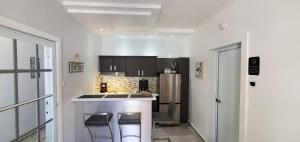 a kitchen with a counter with stools and a refrigerator at Palmeras Del Mar in Isabela