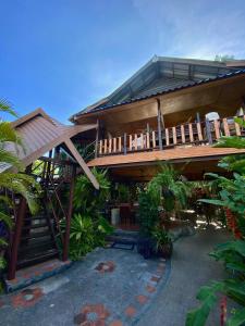 ein Haus mit einer Terrasse und einer Treppe davor in der Unterkunft Shanti Lodge Phuket in Chalong 