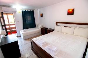 een slaapkamer met een groot wit bed en een bank bij Famagusta in Vama Veche