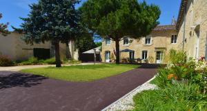 a driveway in front of a house with trees and grass at Gites Jardin-darcy - Piscine au sel in Bois