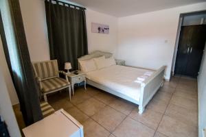 a small bedroom with a bed and a chair at Famagusta in Vama Veche +5 photos