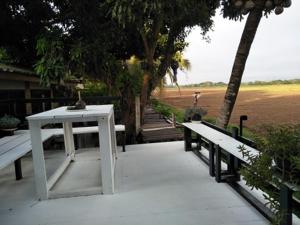 a white table and benches on a patio at Oui Kaew Homestay in Phayao