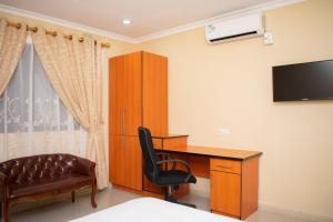 a bedroom with a desk and a chair and a television at Travelodge in Blantyre