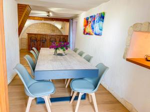 ein Esszimmer mit einem blauen Tisch und Stühlen in der Unterkunft L’Écrin de Charance in Gap