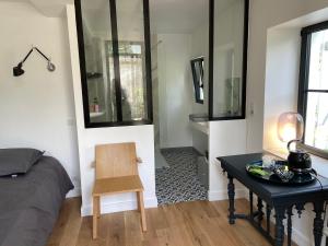 a bedroom with a bed and a desk with a chair at Cocon en lisière de forêt in Bourron-Marlotte