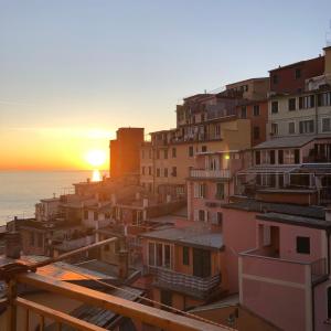 una vista de una ciudad con la puesta de sol en el fondo en Giardi, en Riomaggiore